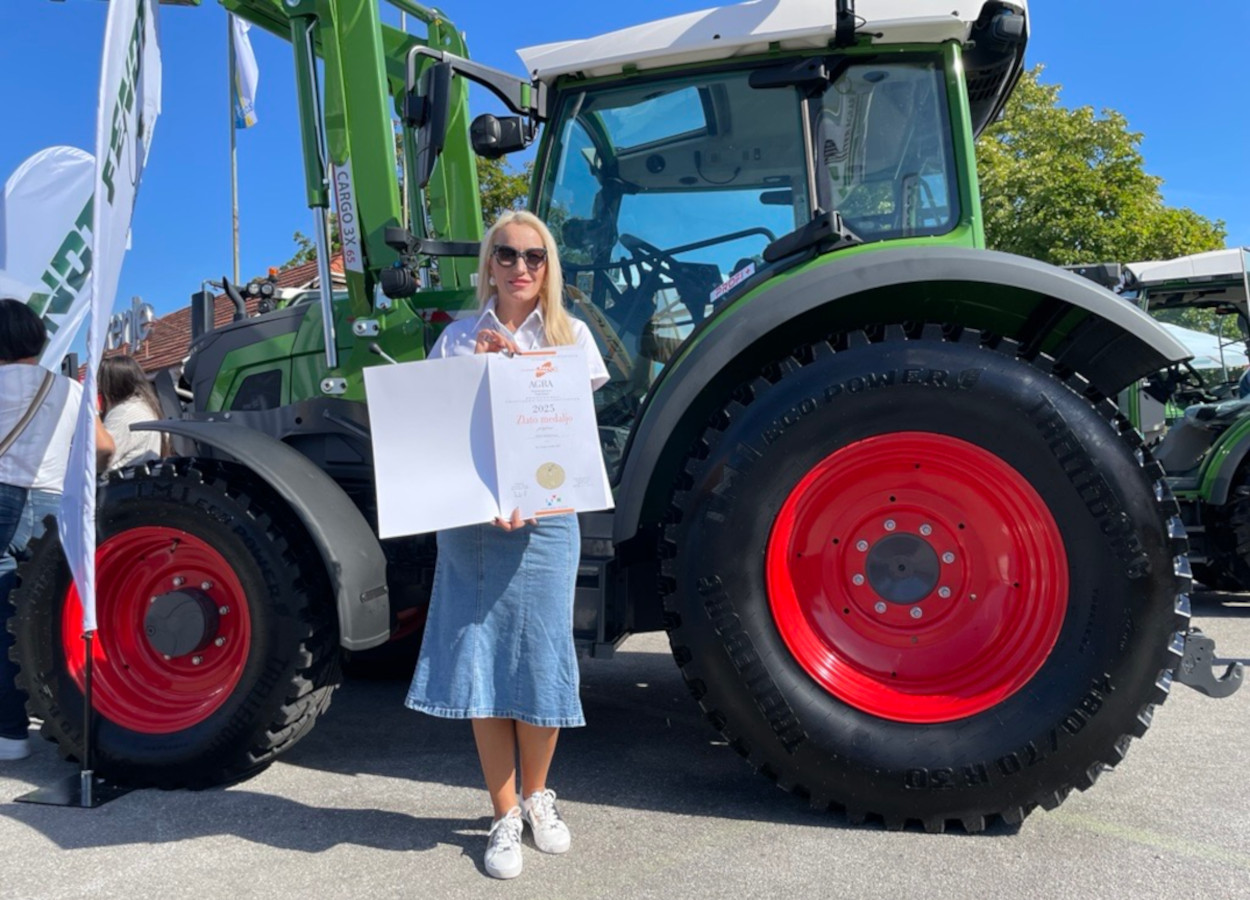 Alja Curkovic ("head" de marketing da Inter Agrar) com o prêmio em frente ao Fendt e100 Vario