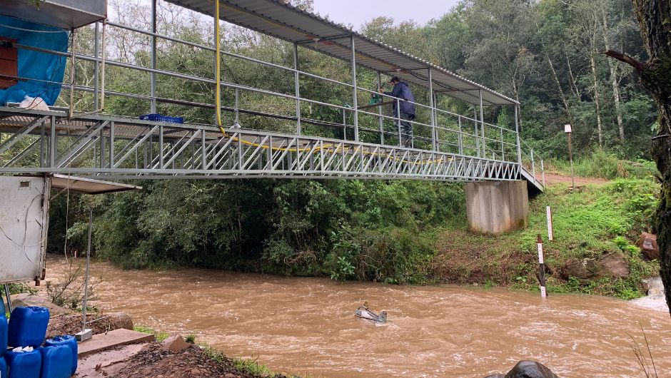 Imagem 2: pesquisador coletando amostras de sedimento em arraste durante evento de chuva no Rio Guarda Mor